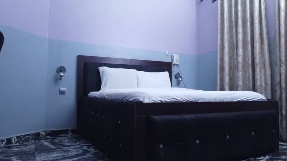 Standard Room with a made queen bed and warm bedside lighting