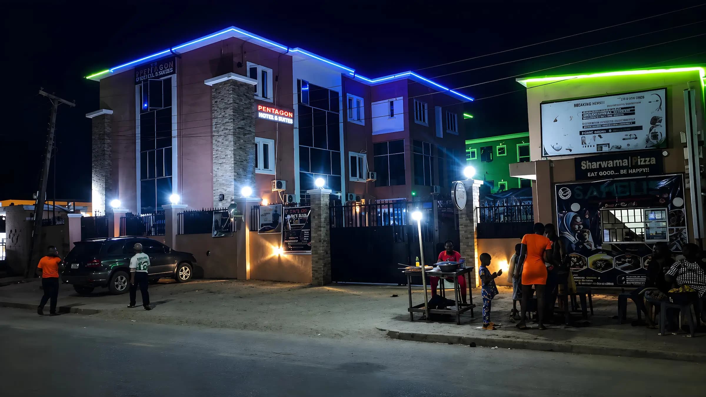 A made-up guest room at Pentagon International Hotel & Suites, lit warmly at dusk